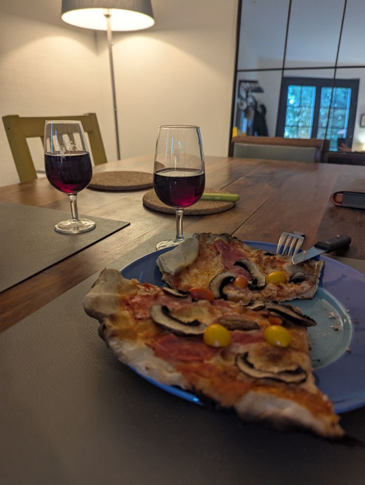 Pizza et verre de vin sur une table en bois