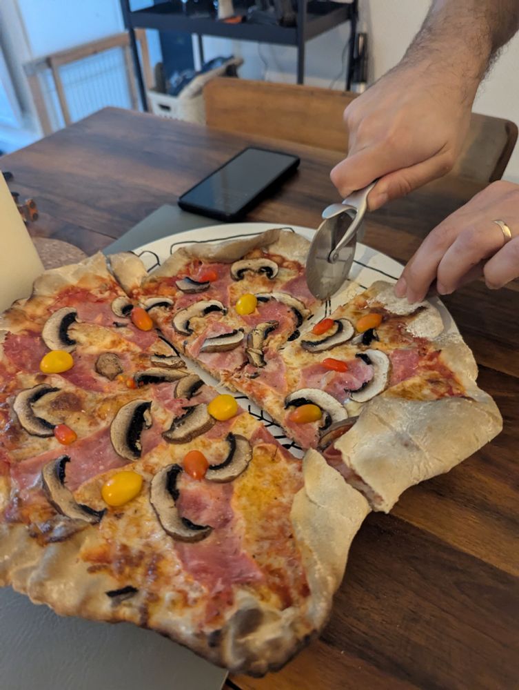 Pizza n°1 en cours de découpe par un homme MARIÉ (il a une alliance)