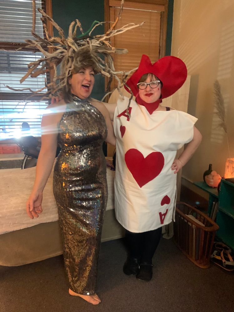 My pal as Lady of the woods in a sequined dress and medusa-like headdress of sticks. me as the ace of hearts card with a heart-shaped headdress 