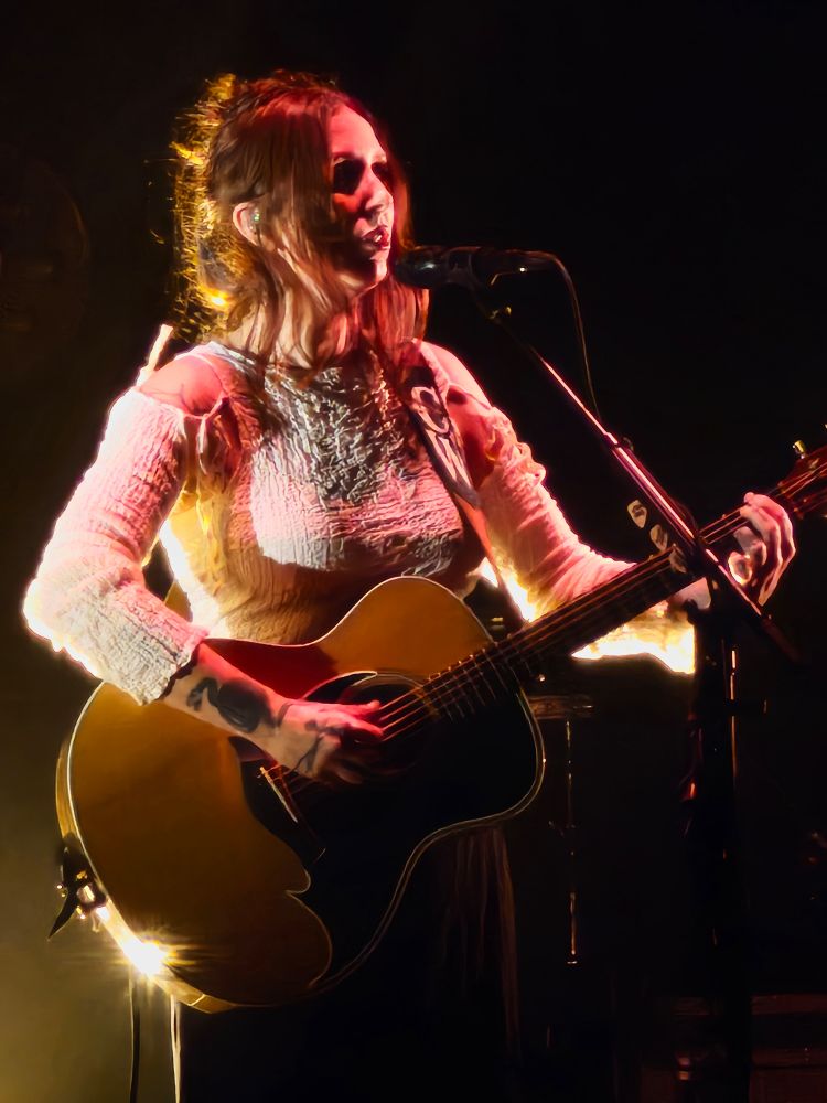 Singer Chelsea Wolfe playing a guitar. 