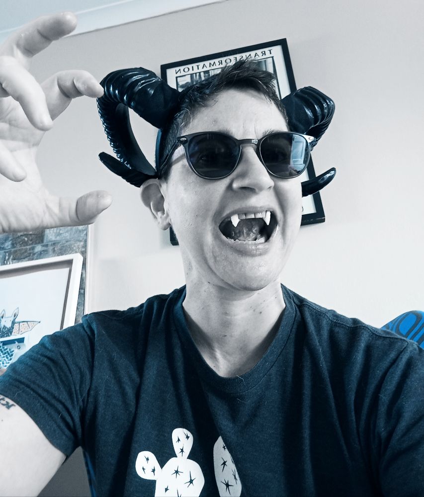 Me wearing black ram horns, sunglasses and fangs, making a daft attempt at a scary face