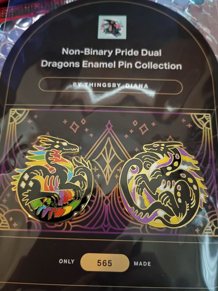 A close-up of the two enamel pins.