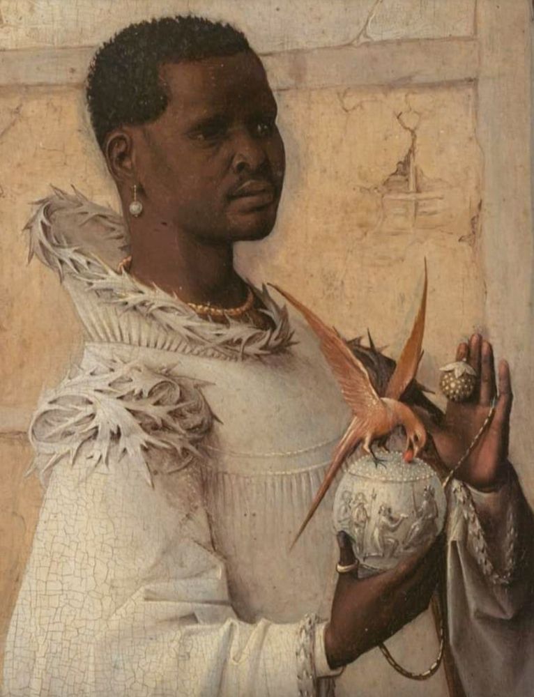 Oil painting of a dark-skinned man wearing elaborate white robes decorated with a pattern of leaves, holding an ivory ornament on which a red bird is perched. 