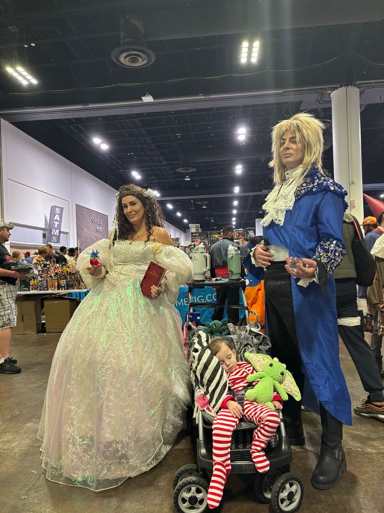 A family in costume as Sarah, Jareth and baby Toby from The Labyrinth 