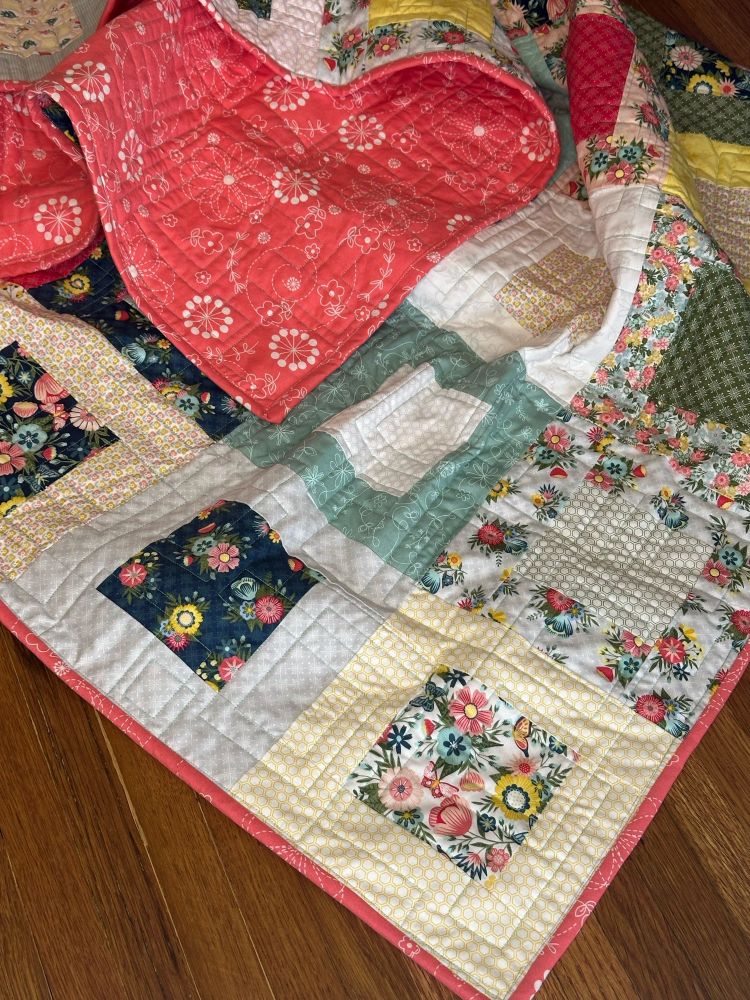 Zoom in on corner of quilt with another corner flipped over to see the backing.  Backed and bound with Kimberbell Peachy Pink Doodles.

