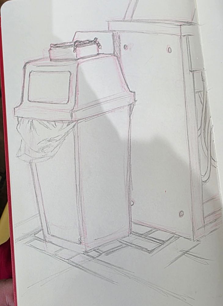 A rough still life line art pencil sketch of an industrial trash can with a zipped toolbar on top in front of a split wall containing the rough suggestion of pipes and tubes. The floor maps the first edges of a zigzag faux brick pattern of tile. 