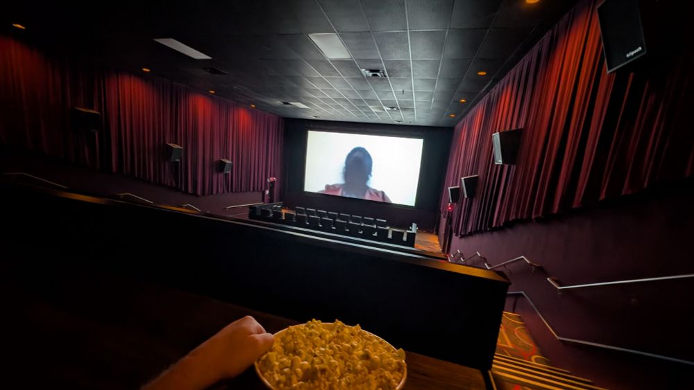 nobody else is in the theater so far view of trailers from my customary seat in the back corner, you can see a bucket of popcorn is on my lap