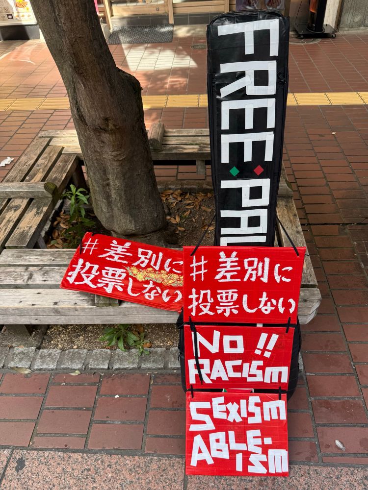 街の一角、立てかけたプラカード。#差別に投票しない、No Racism Sexism ableism.