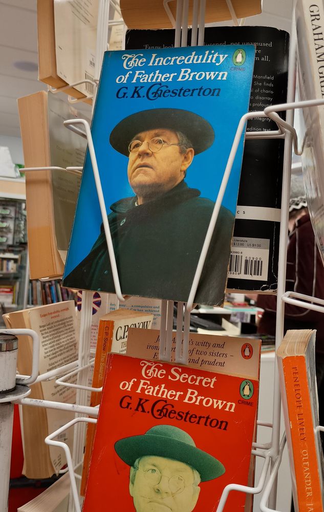 A book on a rack in a shop. The cover says The Incredulity of Father Brown and features a visibly incredulous priest.
