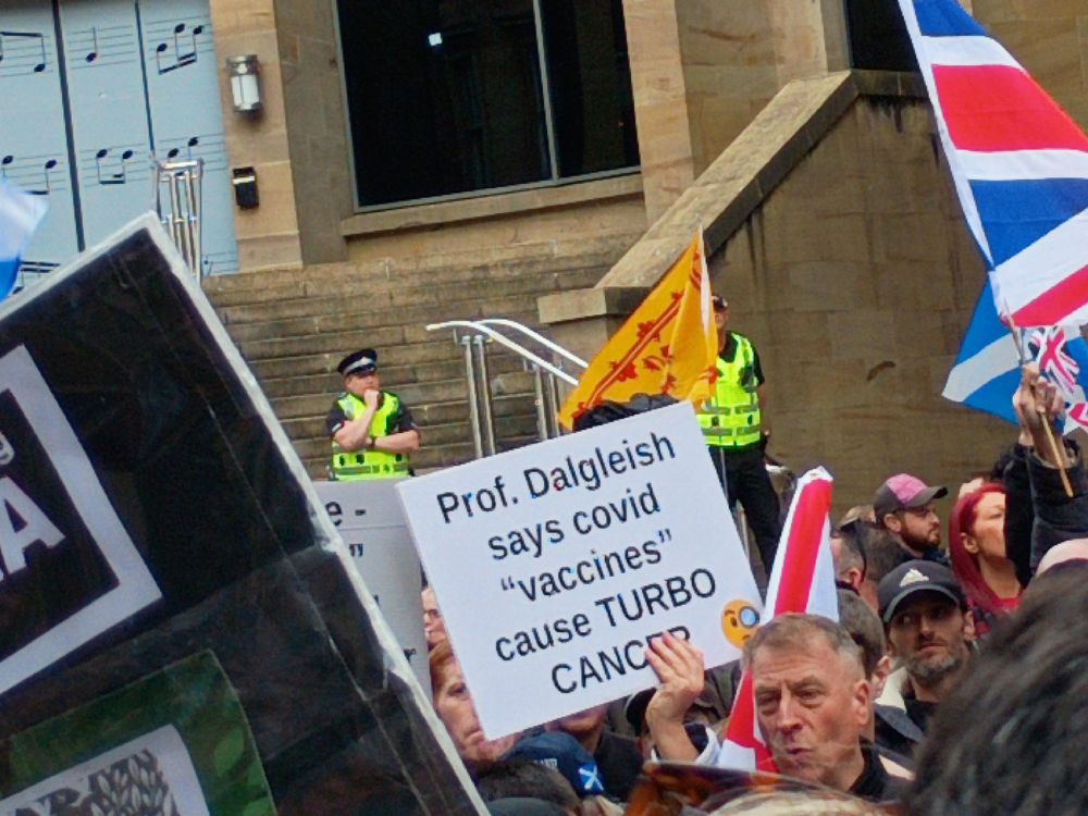 A fash sign reading "Prof. Dalgleish says covid "vaccines" cause TURBO CANCER"
