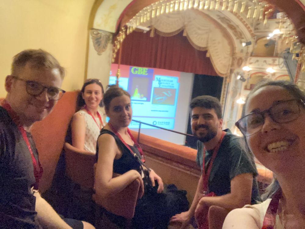 Five scientists on an ornate balcony at a conference venue