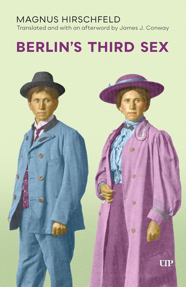 A book cover with a backdrop the colour of a green carnation, with two colourised photos showing an individual in two different exposures, one in masculine-coded clothing from the early 20th century, and one in feminine-coded clothing. On the left the individual is wearing a suit coloured mid-blue with a white starched collar and purple tie and waistcoat and a black hat. On the right the individual is wearing a pink overcoat with wide sleeves over a light-blue blouse and a purple skirt, as well as a purple broad-brimmed hat with a blue ribbon. The text at the top reads MAGNUS HIRSCHFELD/Translated and with an afterword by James J. Conway/BERLIN’S THIRD SEX