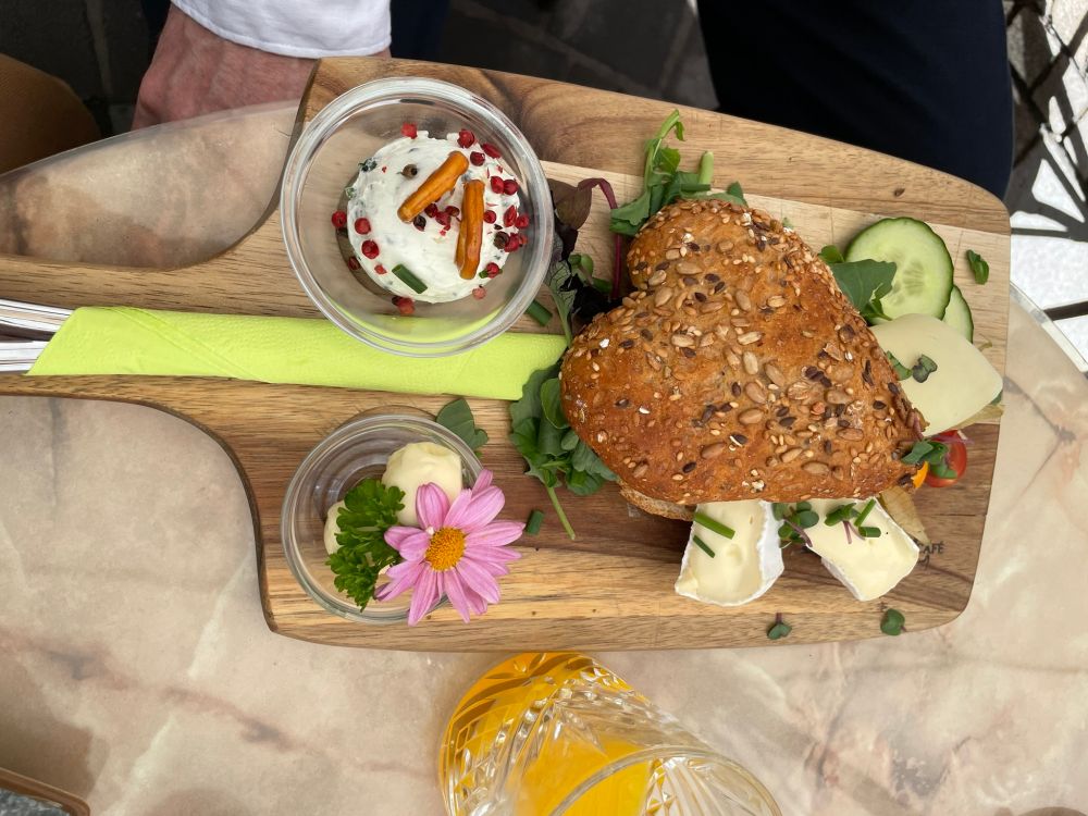 Cheese board with a heart-shaped bun and a butter pot with a pink daisy