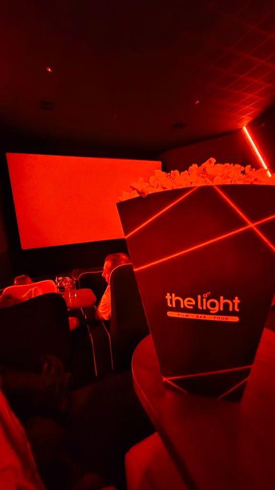 An extremely red tinged photo of popcorn at the cinema before the screening starts 