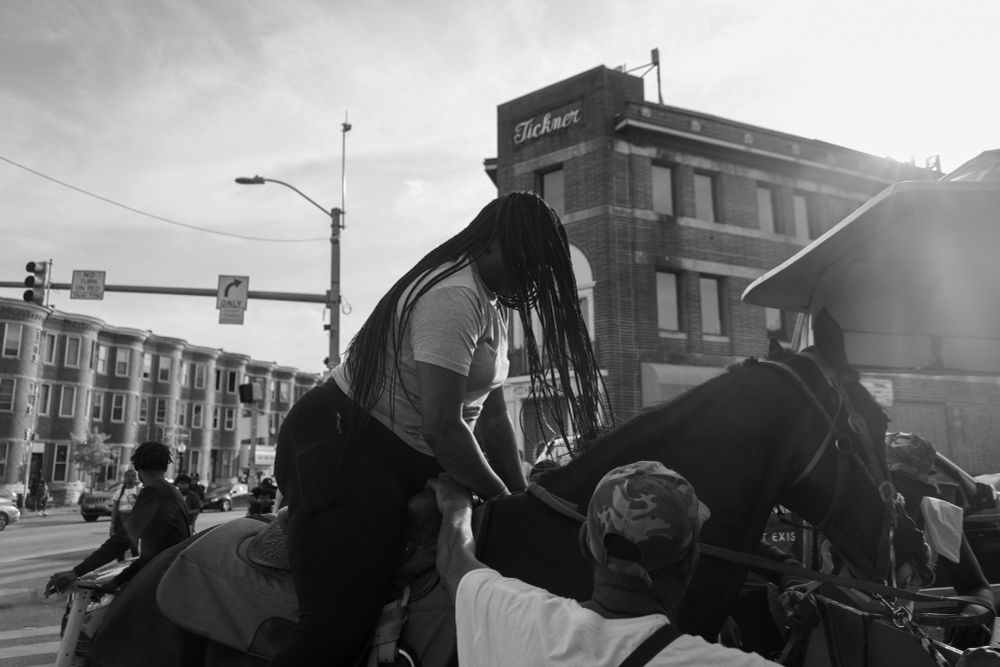 A lady getting on a horse