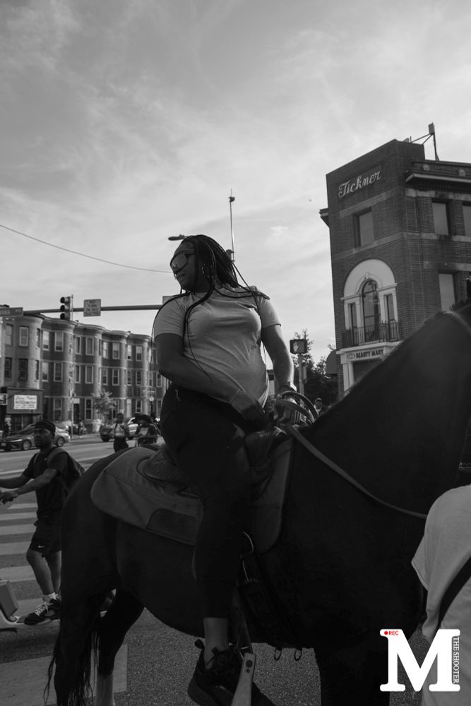 A lady sitting on a horse, looking behind her.