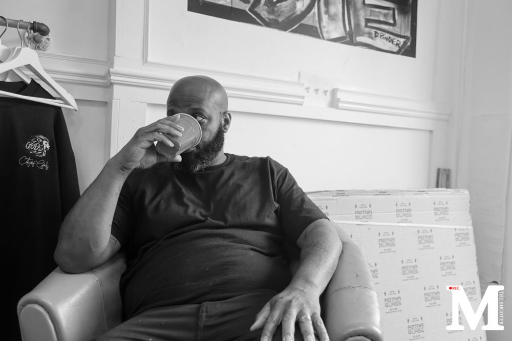A man sitting in a chair sipping from a solo cup.