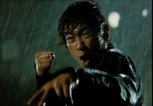 Rain and wind-swept Sonny Chiba, looking real eager to deliver a knuckle supper. From The Street Fighter (1974).