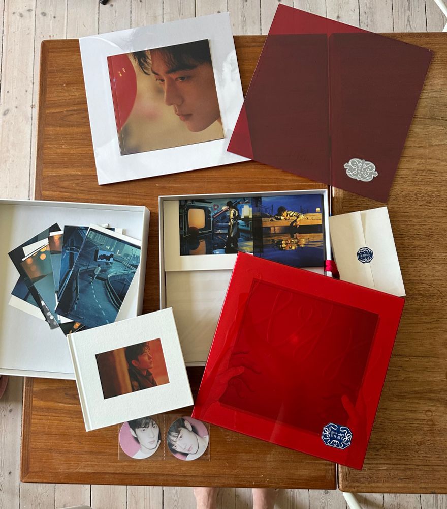 Xiao Xhan’s “我们” vinyl album and all the photo books, postcards, transparent red vinyl plate spread out on a table