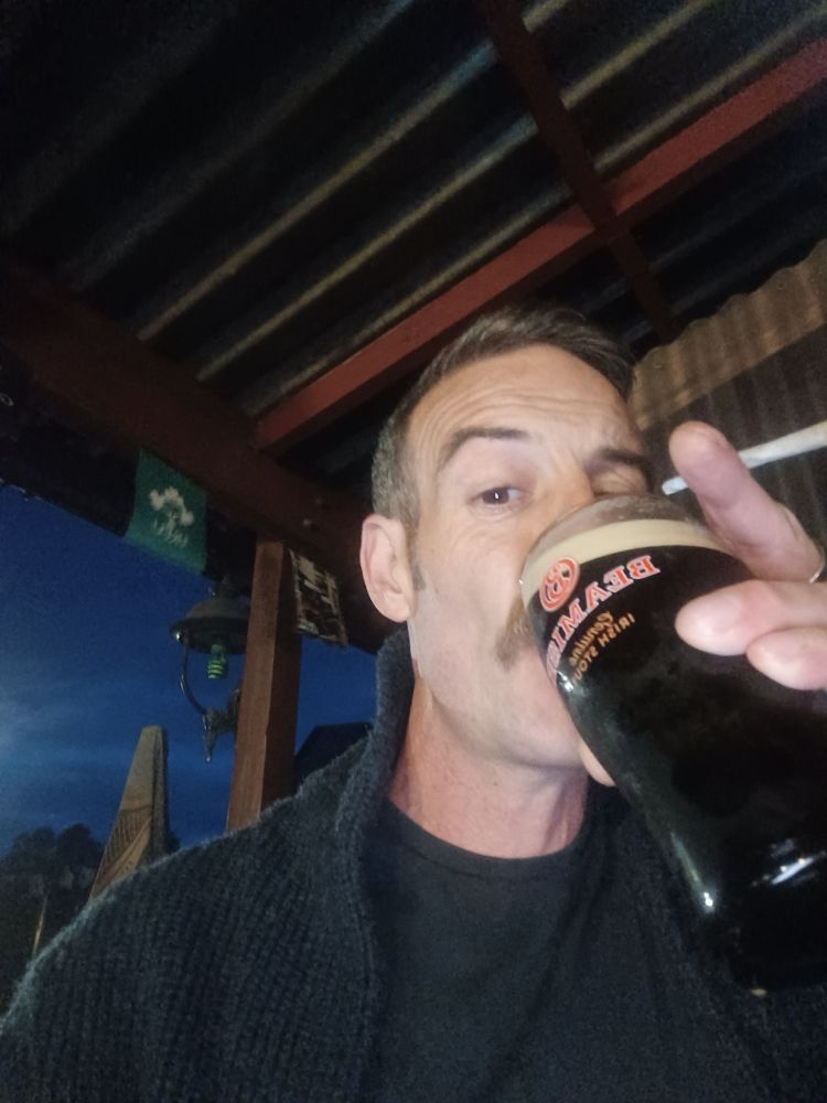 Selfie, slugging a pint of Beamish.
I'm wearing a navy cardi over a black T-shirt. I'm clean shaven except for my tache.