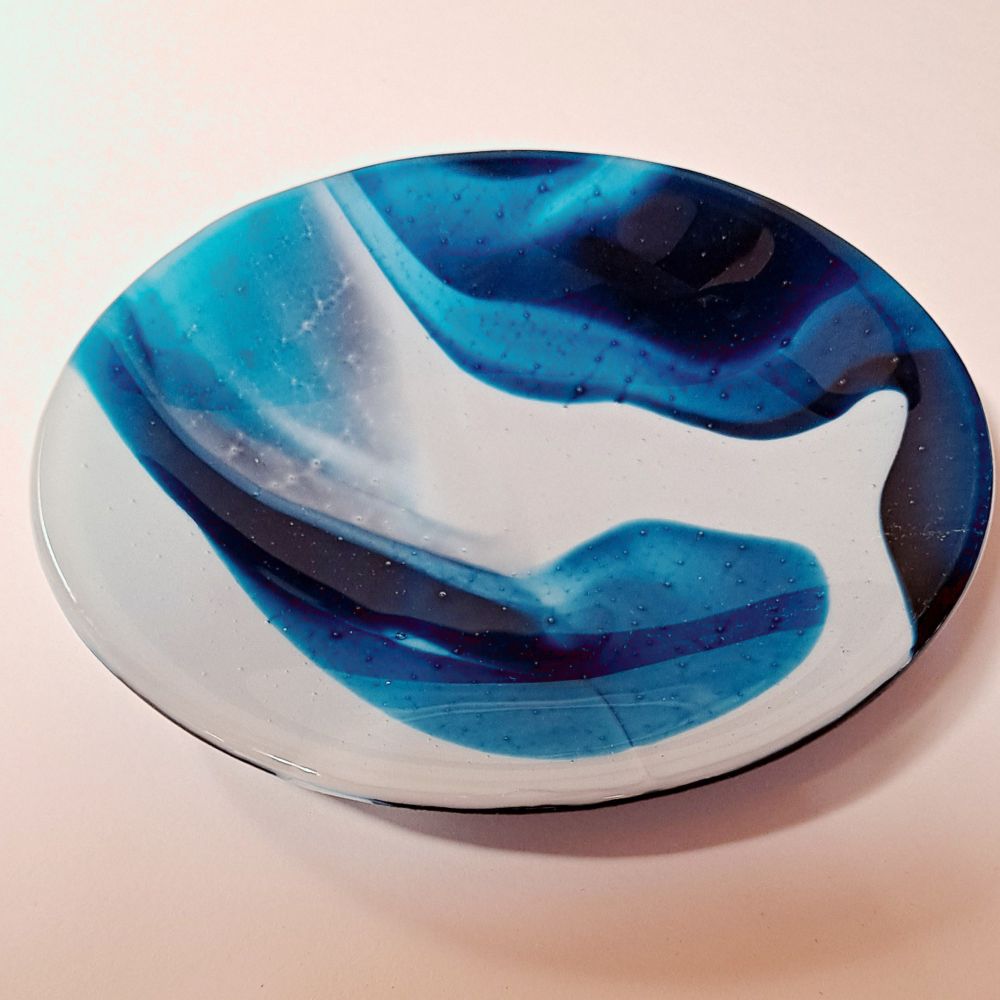 a shallow fused glass bowl with white/blue/turquoise swirls