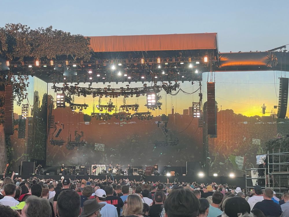 Main stage at Pearl Jam Live at Hyde Park, 2022. The stage is lit in the sunset light, with screens acting as a mirror reflecting the massive crowd of Hyde park 
