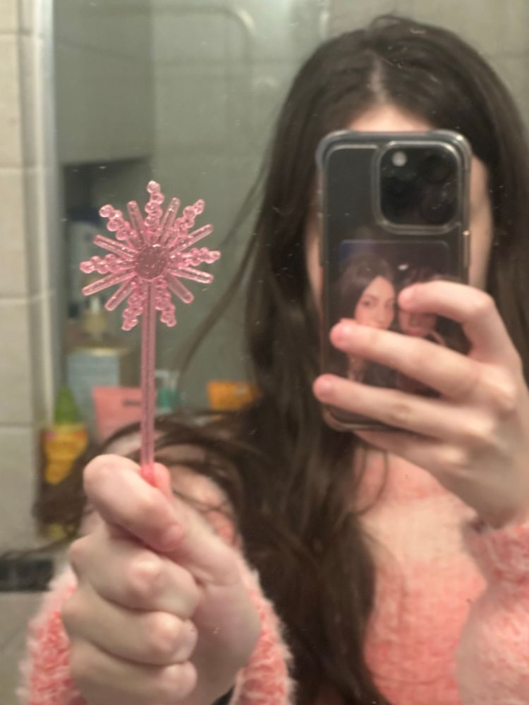 ellie holding the glinda wand stirrer from the wicked chili’s margaritas