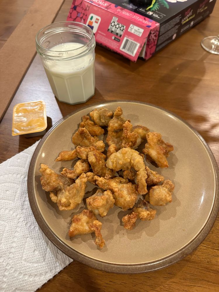 plate of chicken with a glass of milk and package of chick fil a honey mustard 