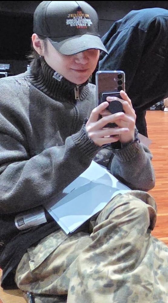 Yoongi wearing a grey, distressed, zip-up cardi/jacket, the same brand as Namjoon's. 