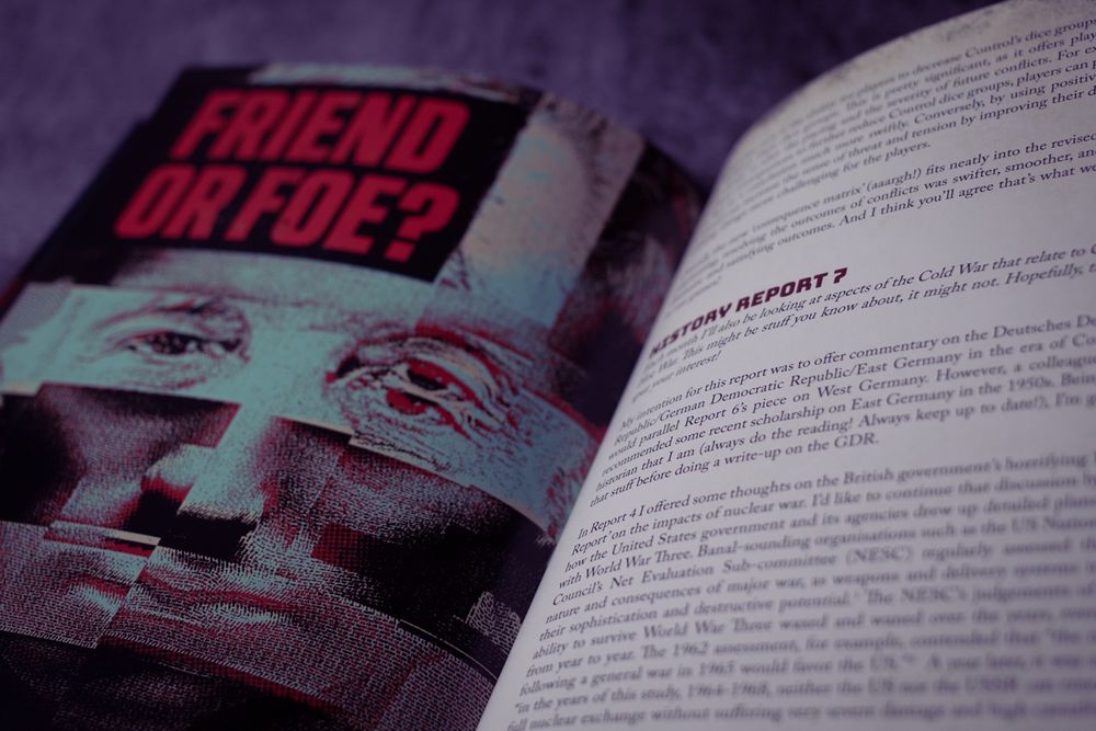 A close up on pages from the unique, one-off, Cold City Hot War Reports One to Seven. This spread shows a poster with a mosaic face saying "Friend or foe".