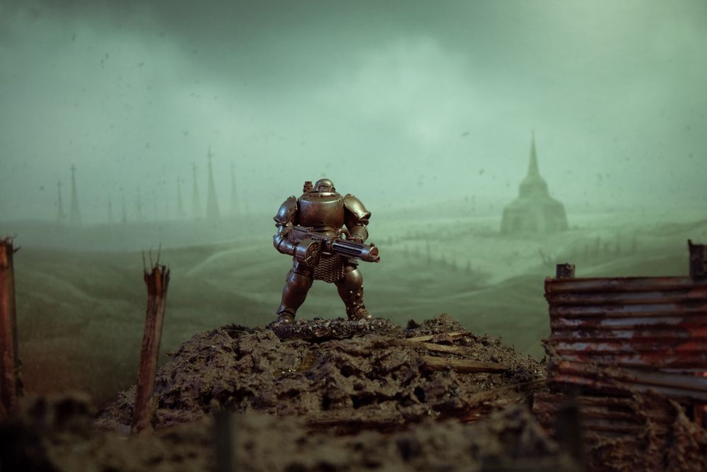 A Trench Crusade miniature - Mechanised Heavy Infantry-  in front of a backdrop showing a battlefield.