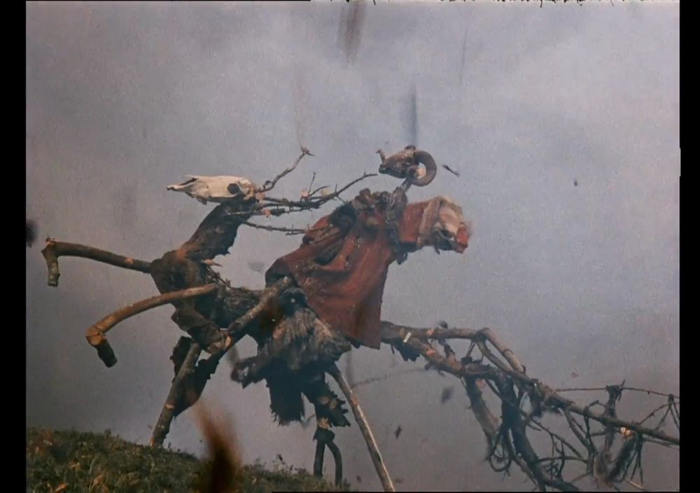 A still from historical drama "Shadows of Forgotten Ancestors" (1964) film by Sergei Parajanov showing very difficult to describe effigy of a horse made of sticks and skulls. 