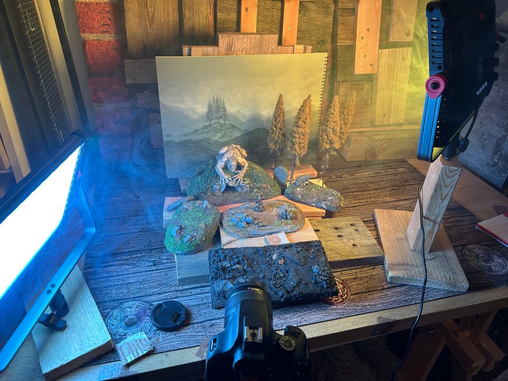A behind the scenes shot of Fenris Games’ mighty Grendel model with some scatter terrain in front of a backdrop from the first Backdrops Book. 