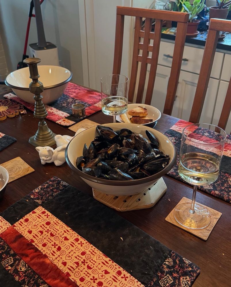 Our kitchen table set with mussels and glasses of white wine 