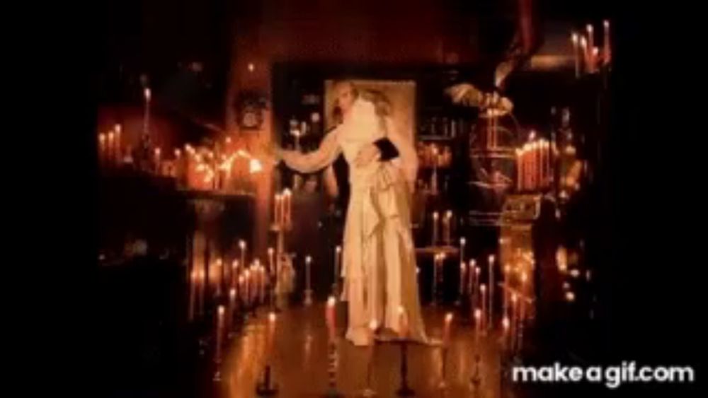 a man and a woman are dancing in a room filled with candles .