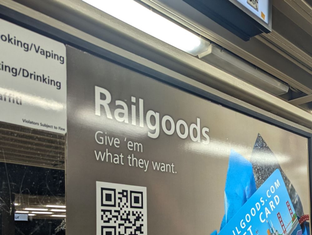 An advertisement for something on a BART platform called "rail goods." The subtitle says "Give 'em what they want."