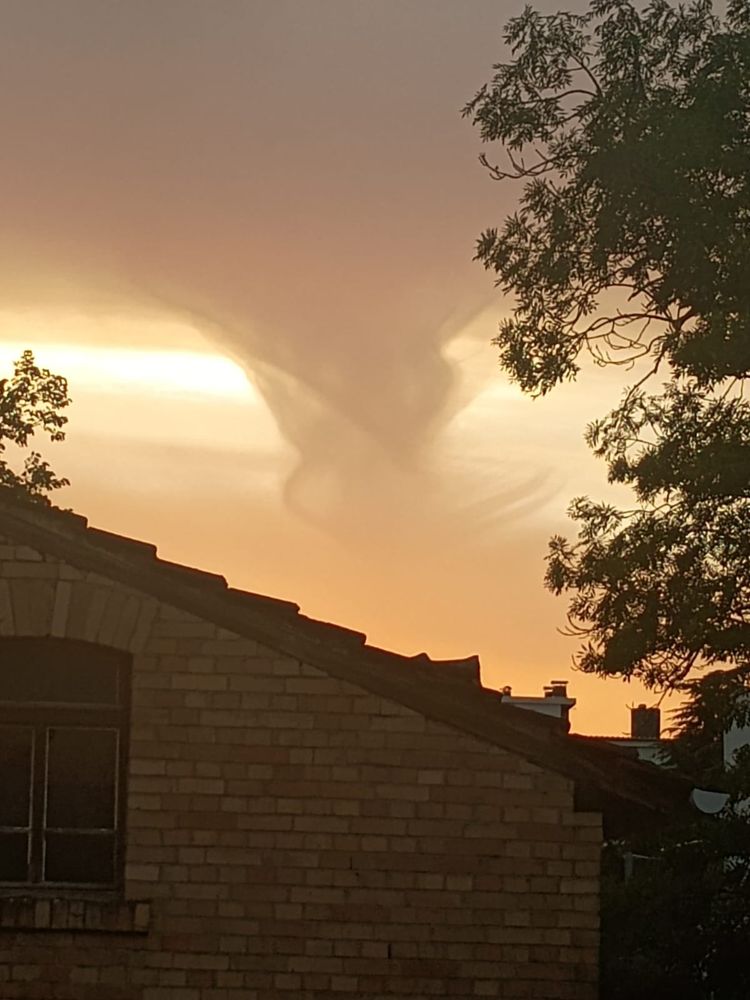 Abendhimmel: aus einem Berg grauer Wokken scheint eine Wolke herauszubrechen, die ein bisschen an eine Windhose erinnert