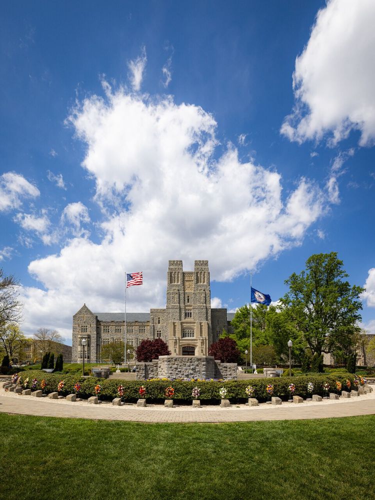 The April 16 Memorial is pictured in front of Burruss Hall against a blue sky.
