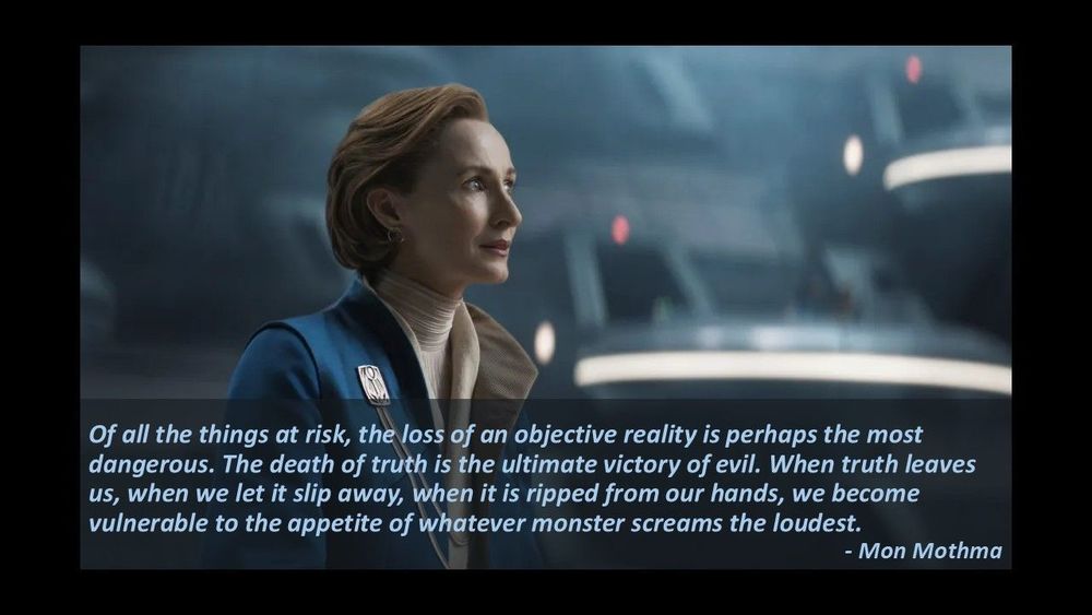 A side profile shot of Mon Mothma addressing the Imperial Senate from Andor Season 2, episode 9. There is a caption on the bottom quarter of the picture that reads, in blue text: "I believe we are in crisis. The distance between what is said and what is known to be true has become an abyss. Of all the things at risk, the loss of an objective reality is perhaps the most dangerous. The death of truth is the ultimate victory of evil. When truth leaves us, when we let it slip away, when it is ripped from our hands, we become vulnerable to the appetite of whatever monster screams the loudest." - Mon Mothma