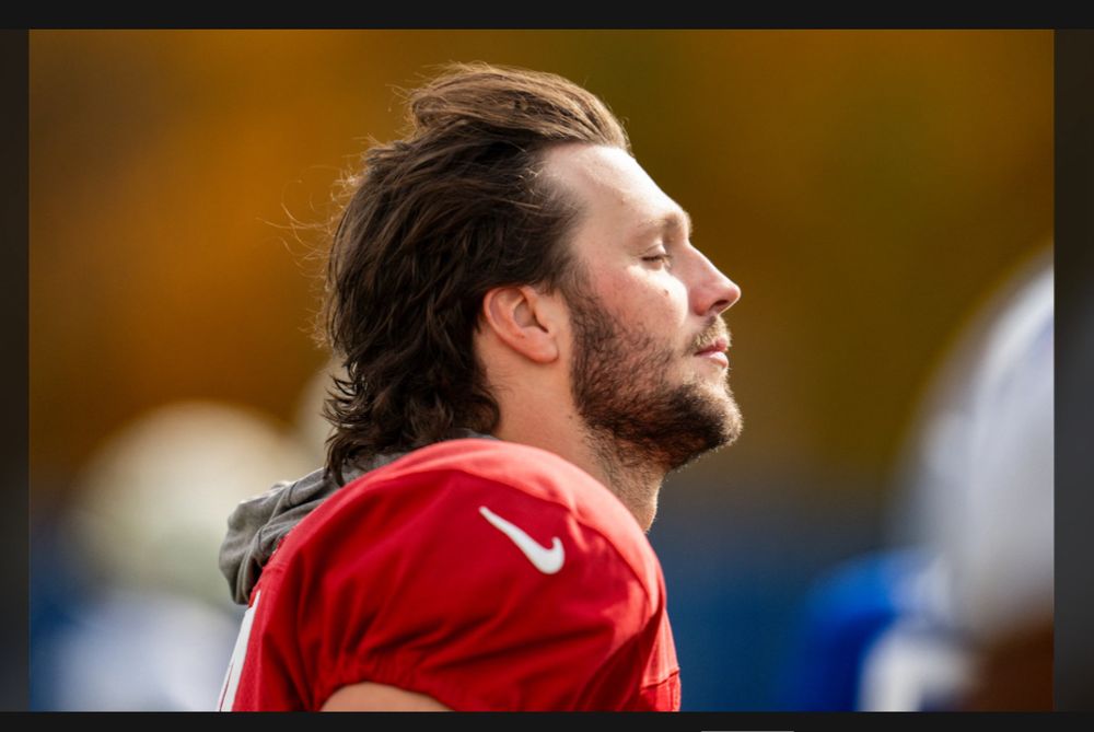 Profile photo of Buffalo Bills quarterback Josh Allen showing endless aura with eyes shut and hair flowing. 