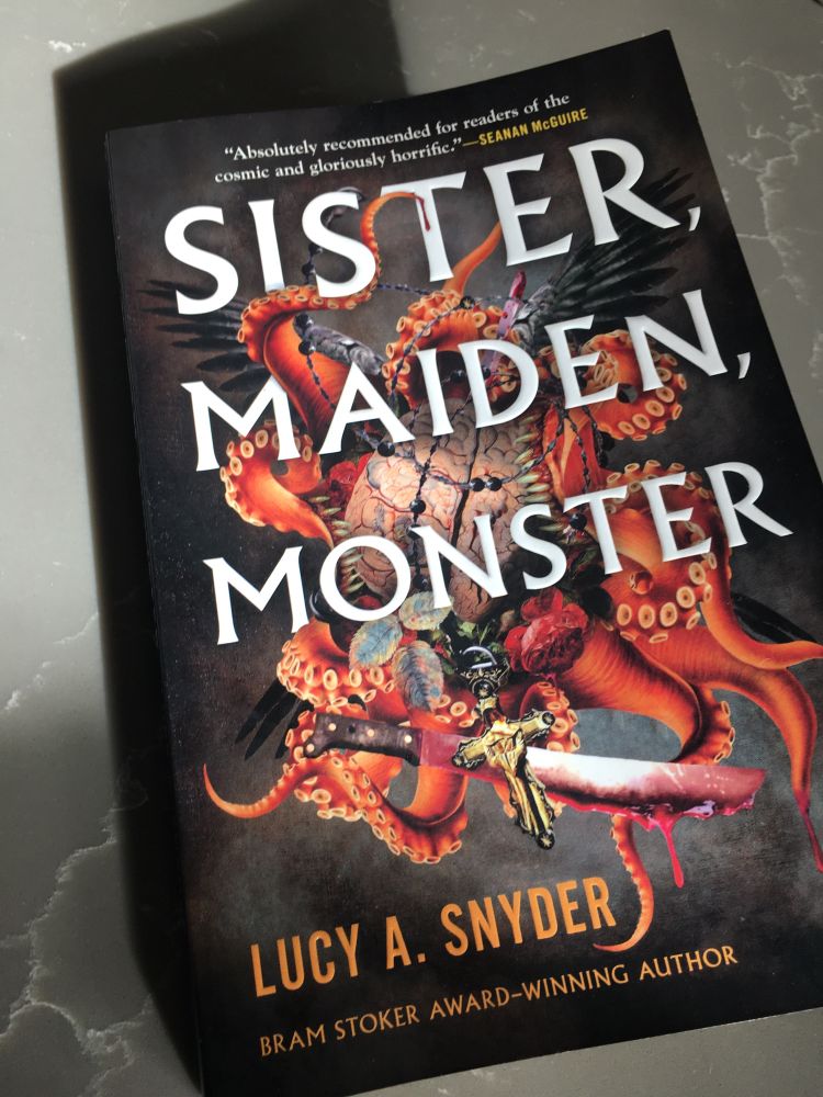 Paperback book titled sister, maiden, monster