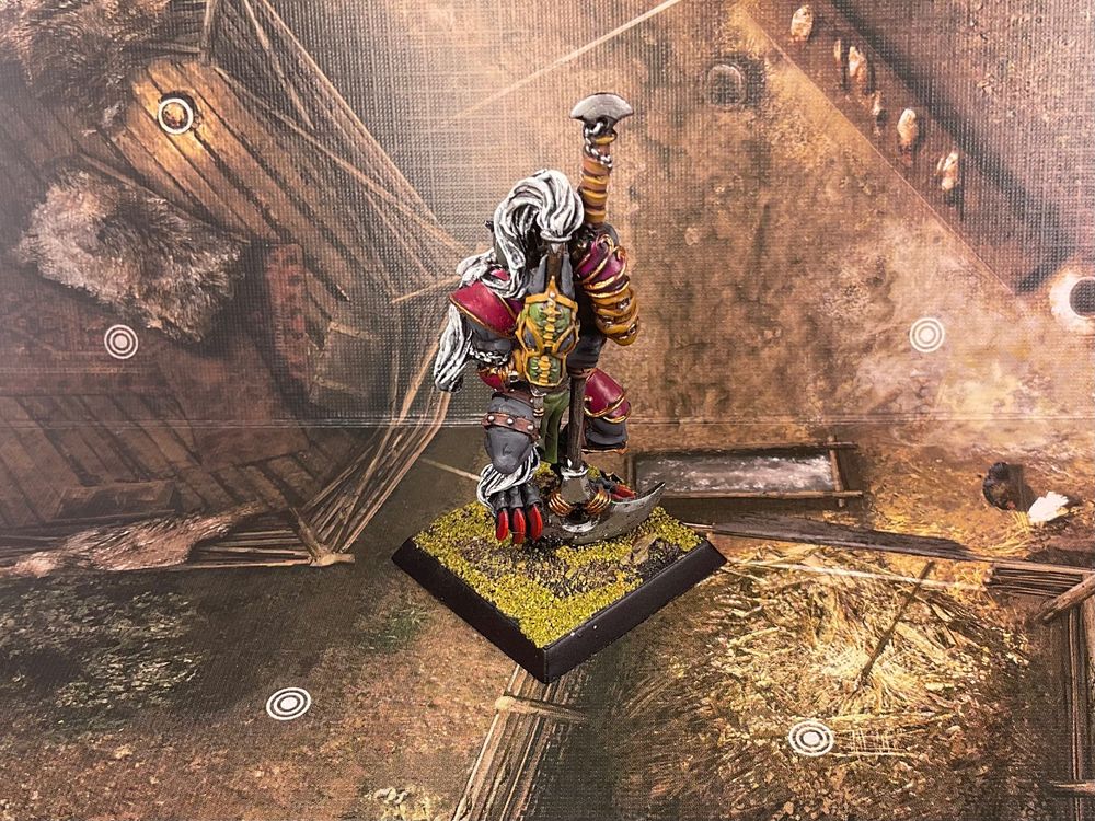 A masked armoured werewolf in bondage, a Devourer of Vile-tis holds a monks spade inspired polearm. Nemetis the Sacrilegious by Rackham Miniatures.