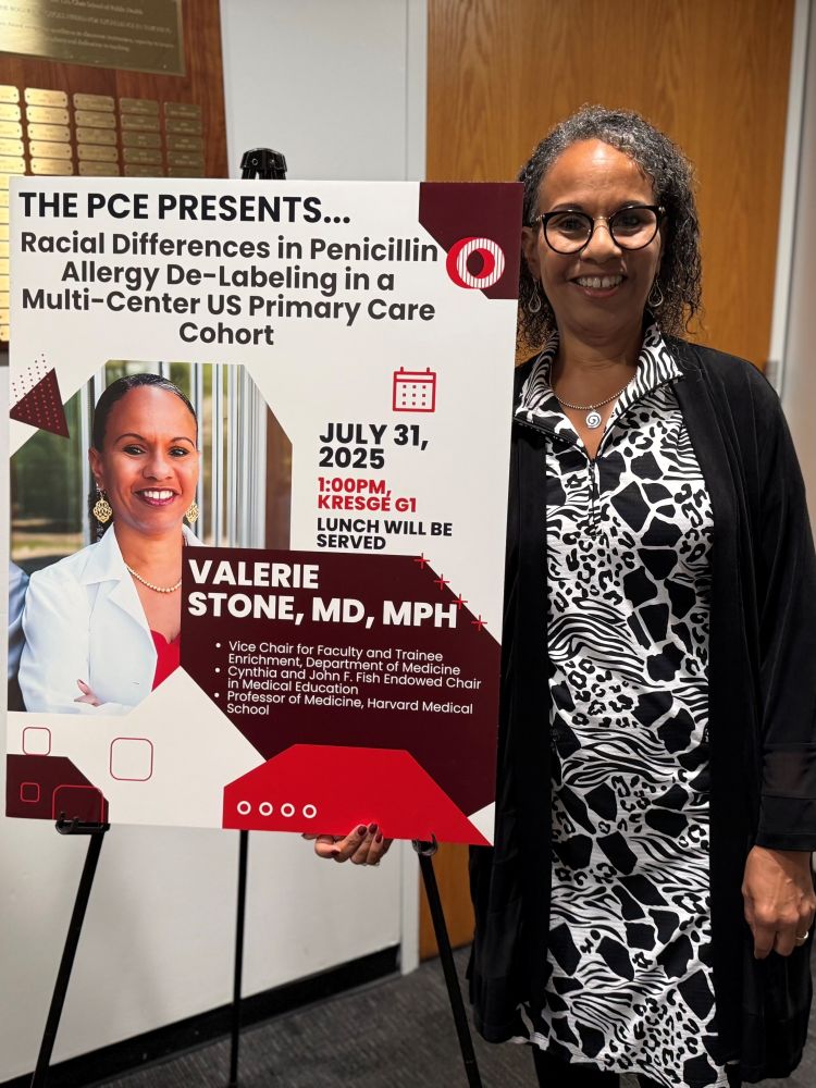 Dr. Valerie Stone standing next to a poster board about her talk. 