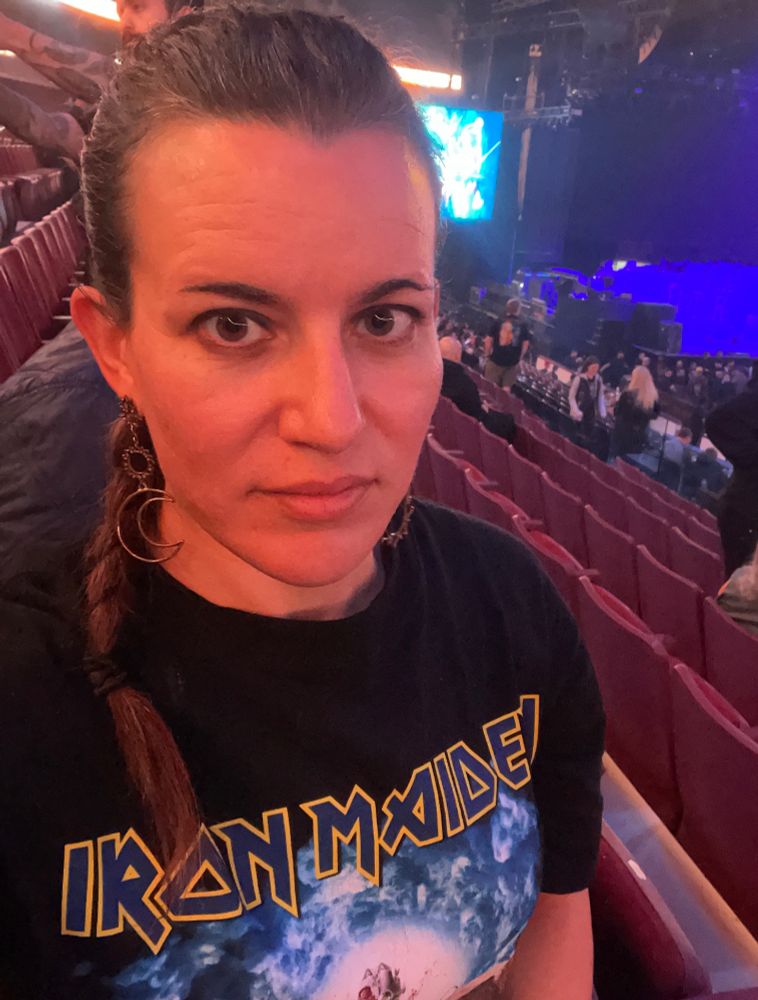 Sitting in stadium. Girl rock t-shirt in front of arena and stage