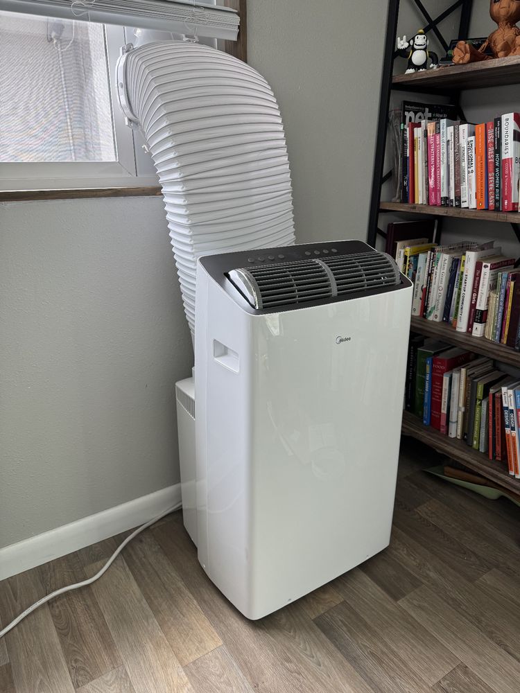 Photo of a Midea Duo portable AC unit connected to a sliding window.