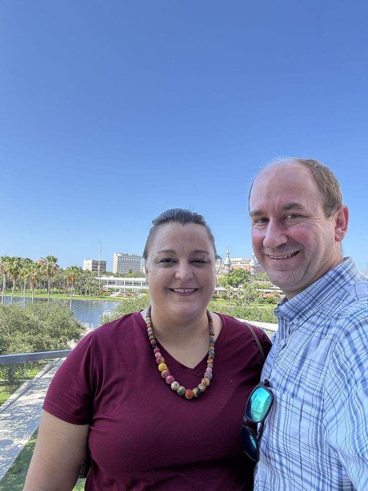 Selfie of Amy and I from the outdoor deck at Tampa Museum of Art with the Tampa riverwalk in the background.