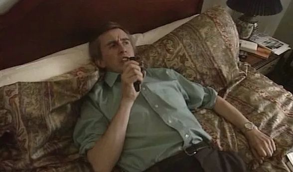 Alan Partridge lying in his bed at the Linton Travel Tavern, speaking another genius television format idea into his dictaphone.
