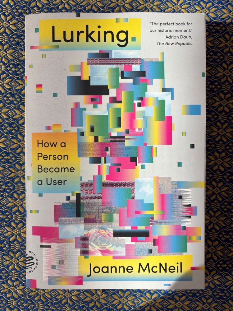 cover of the paperback of Lurking (which was technically published in 2021) but the book as in book debuted five years ago. cover depicts multicolored squares in gradients and distortion that appears somewhat like a pixelated face.