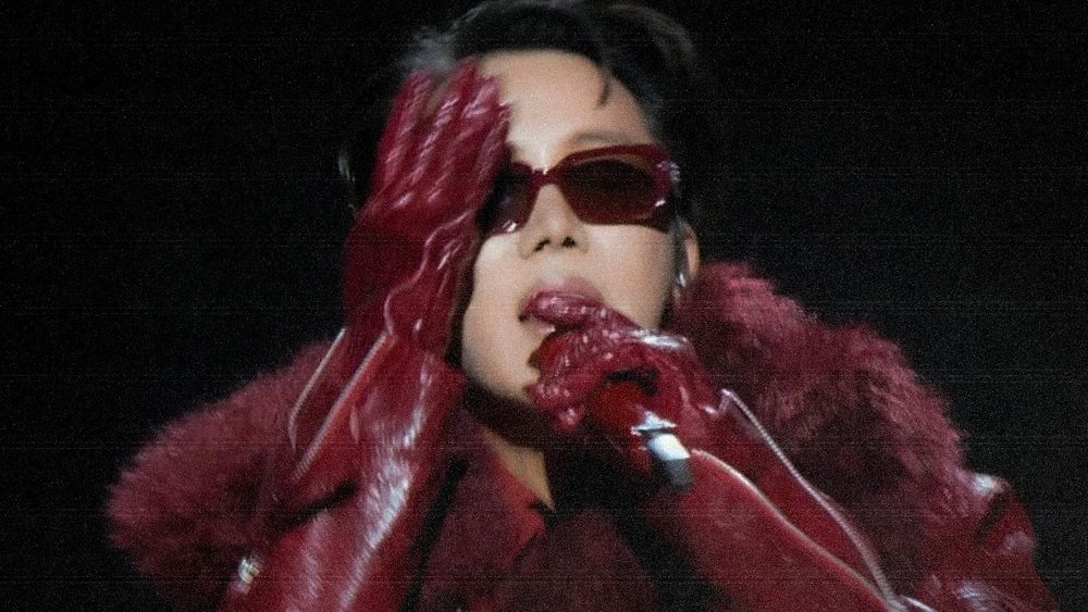 J-hope's red outfit from the hope on stage tour. He's touching the right side of his face with a leather glove and holding the mic with the other, he's SERVING SO HARD