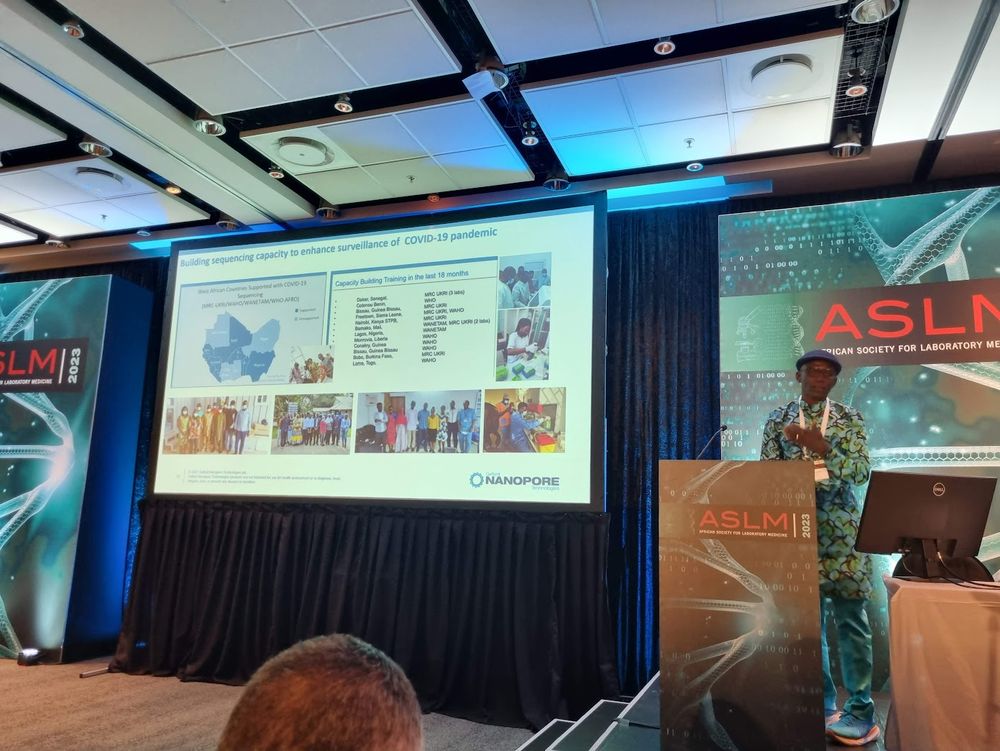 Picture of Prof Abdul Sesay presenting a slide on his genomics & sequencing training partnerships in the West African region